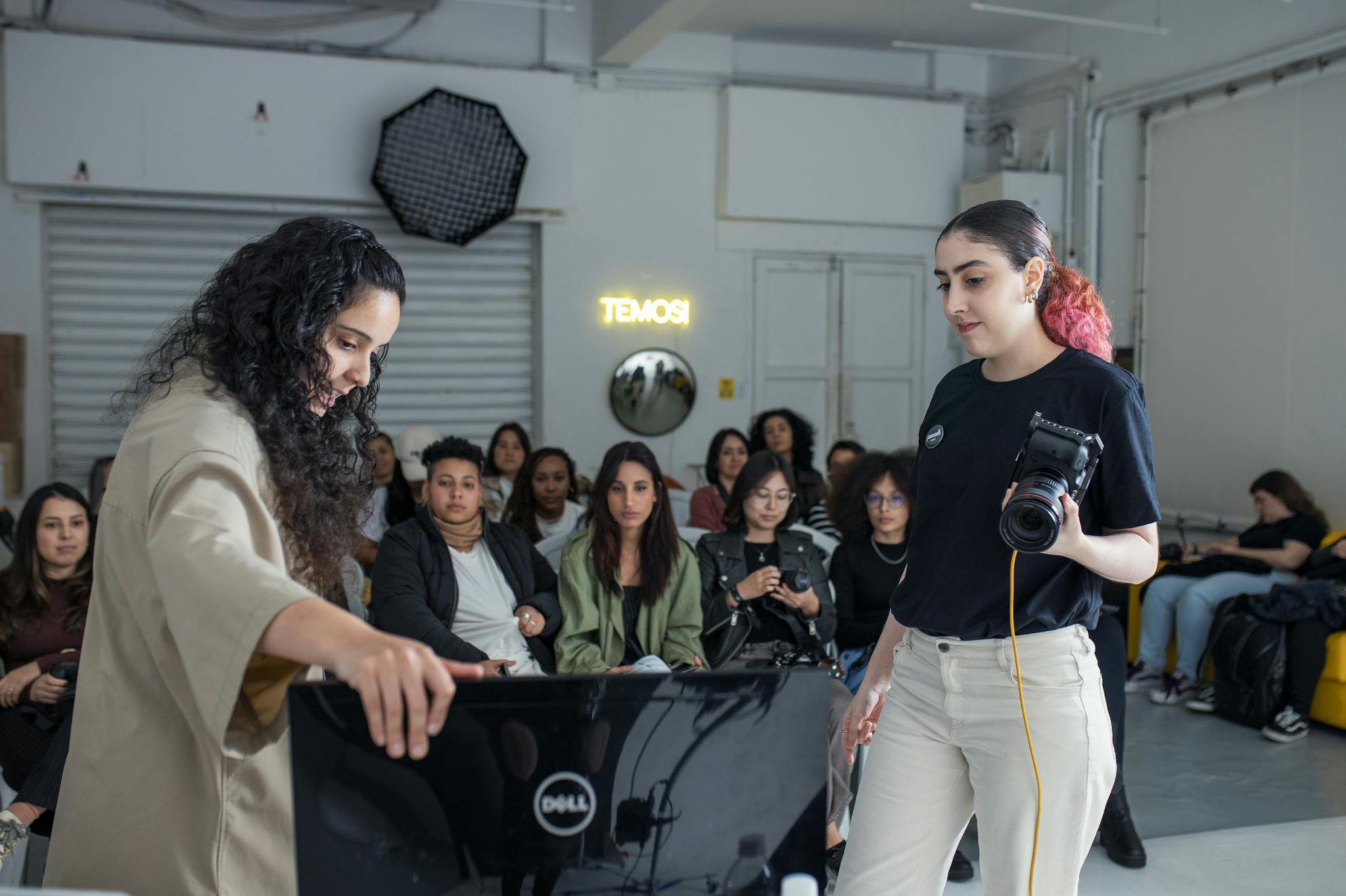 A diverse group engaged in a photography workshop session indoors.