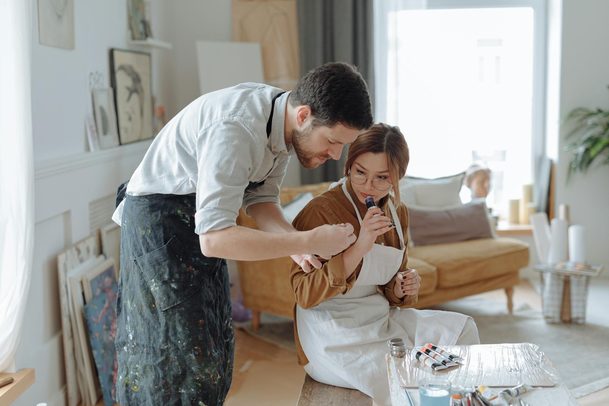 Art teacher guiding student in a cozy studio, exploring creativity.